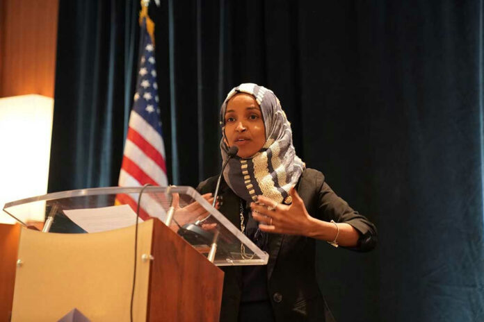 1311568823 Woman speaking at podium with American flag background.
