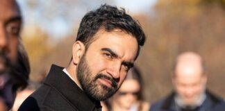 A man with a beard looking towards the camera at an outdoor event