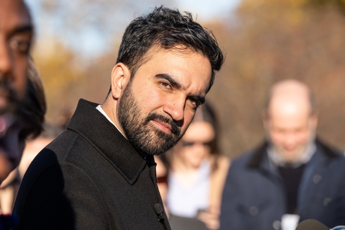 A man with a beard looking towards the camera at an outdoor event