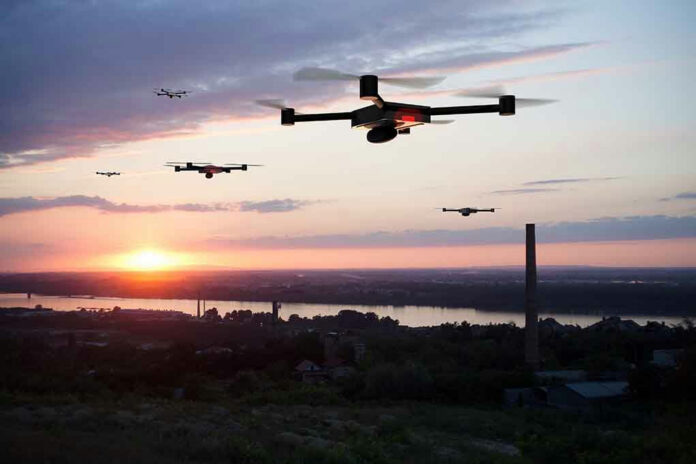1143966755 Drones flying over a landscape at sunset.