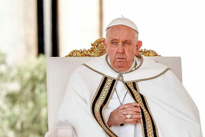 2411762997 Elderly man in white robe sitting on chair.