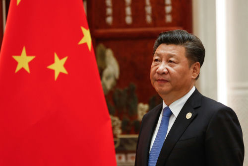 shutterstock1376982239-3jpg A man in a suit beside the Chinese flag.