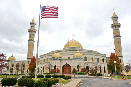 Dearborn,,Mi,-10,Nov,2018-,View,Of,The,Islamic,Center A mosque with a golden dome and minarets, featuring an American flag in front