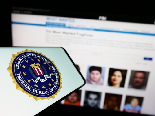 Stuttgart,,Germany,-,07-09-2023:,Mobile,Phone,With,Seal,Of,Us FBI logo displayed on a smartphone with a website showing wanted individuals in the background