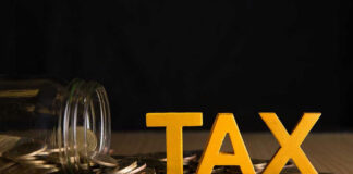 Jar of coins and TAX letters on table.