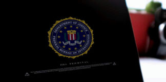 Laptop screen displaying FBI emblem and terminal interface.