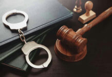 Since WHEN is THIS a CRIME? — He Was SENTENCED FOR IT! Gavel and handcuffs on a desk.