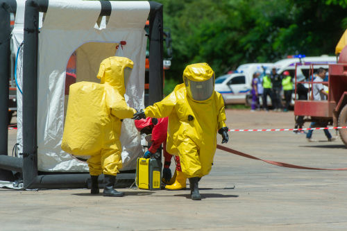Hazmat-suited workers exit a decontamination tent