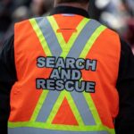 Hot Zone Crash — FIRST EVER RESCUE Search and rescue worker in an orange reflective vest seen from behind