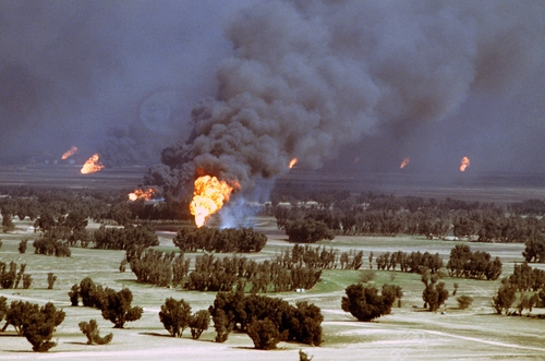 Kuwaiti,Oil,Wells,Were,Set,On,Fire,By,Retreating,Iraqi A large oil fire producing thick smoke and flames in a rural landscape