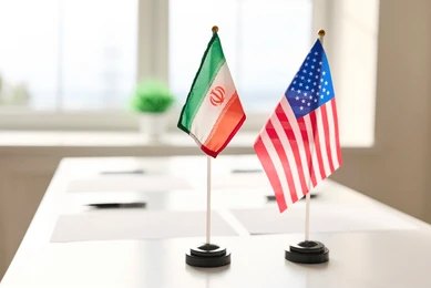 shutterstock_2765360161-1 Mini flags of Iran and the United States on a conference table