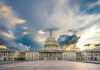 U.S. Capitol building under a dramatic sky at sunset.