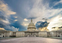 U.S. Capitol building under a dramatic sky at sunset.