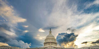 U.S. Capitol building under a dramatic sky at sunset.
