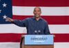 Speaker at podium in front of large American flag