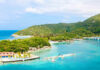 Beach Paradise, Brutal Rules Tropical island with turquoise water and lush green hills.