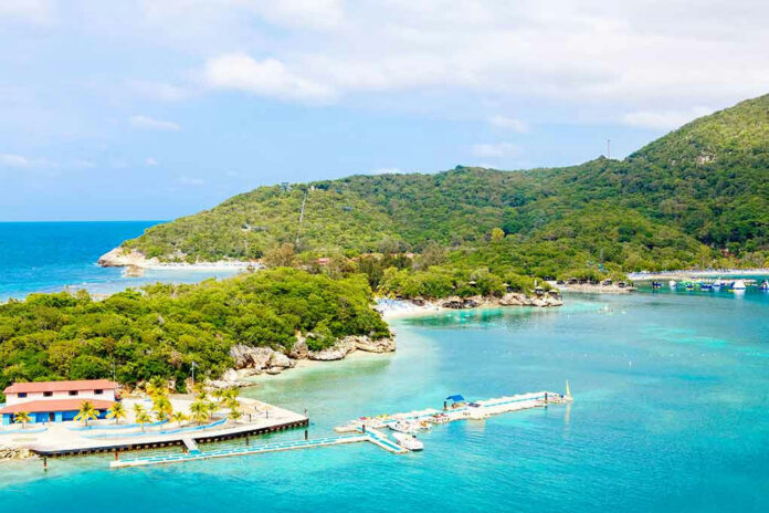 515128393 Tropical island with turquoise water and lush green hills.