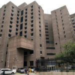 Suspends Sentence: Court Convicts Teen of Attempted Murder Tall concrete building with numerous windows and adjacent parked cars.