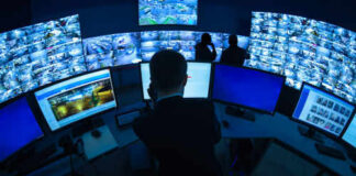 Surveillance control room with multiple monitors and operators.