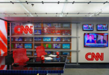 Citizen Branded Traitor Over ICE Critique CNN World Headquarters studio with empty red chairs.