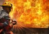 California’s Biggest Wildfire Is Exploding Out of Control Firefighter spraying water at a large blaze