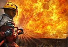California’s Biggest Wildfire Is Exploding Out of Control Firefighter spraying water at a large blaze