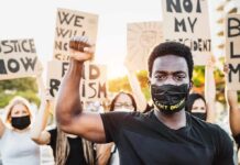 Protester wearing mask raises fist during demonstration