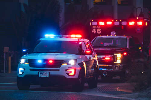 American,Police,Car,And,Emergency,Truck,With,Blue,And,Red Police vehicle and ambulance with flashing lights at night