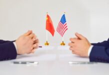 Trump’s Summit Snub: Mexico, Brazil, Colombia Out Two hands of individuals facing each other with flags of China and the USA on the table