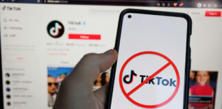 Phone shows TikTok logo with prohibited symbol
