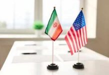 American Freed by Iran, but Was It Goodwill or Another Prisoner Bargain? Mini flags of Iran and the United States on a conference table