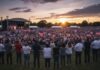 Large crowd at a political rally during sunset