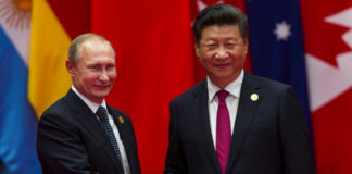 Vladimir Putin and Xi Jinping shaking hands at event.