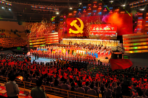 Foshan,City,,China,-,June,27:,Members,Of,The,Communists A large crowd at a celebratory event with performers on stage and fireworks in the background