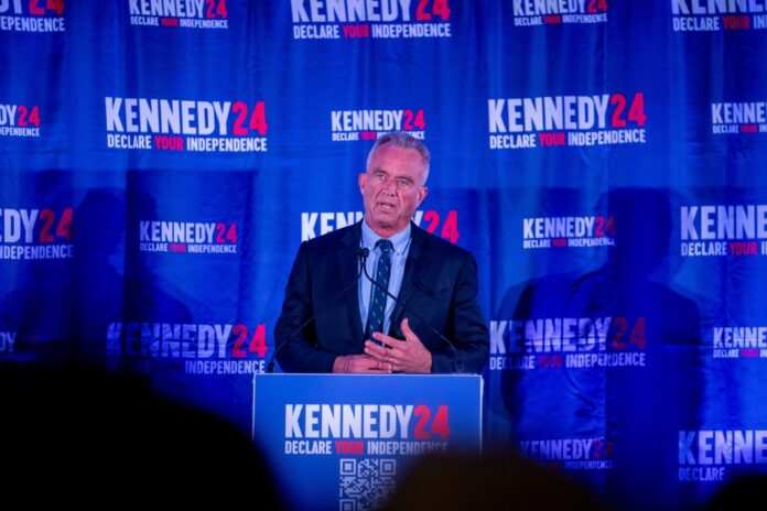 Man speaking at Kennedy 24 event podium.