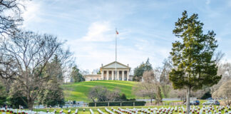 Cemetery with rows of tombstones and wreaths.