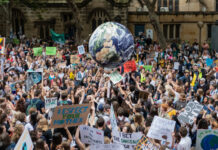 Crowd protesting with signs at a climate change rally.