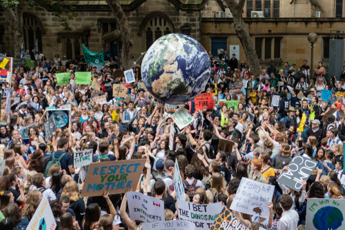 Crowd protesting with signs at a climate change rally.