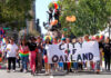 Group marching in Oakland pride parade with banner.