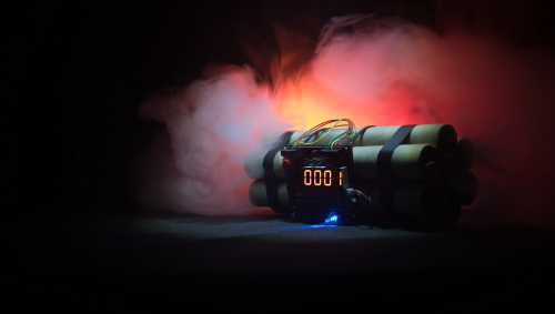 Dynamite time bomb with digital timer in smoky dark background.